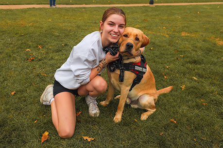 A student hugging a service dog. Links to What to Give A student hugging a service dog. Links to What to Give