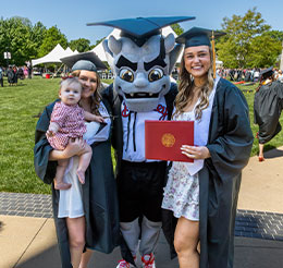 Graduates with mascot. Link to Gifts That Pay You Income.